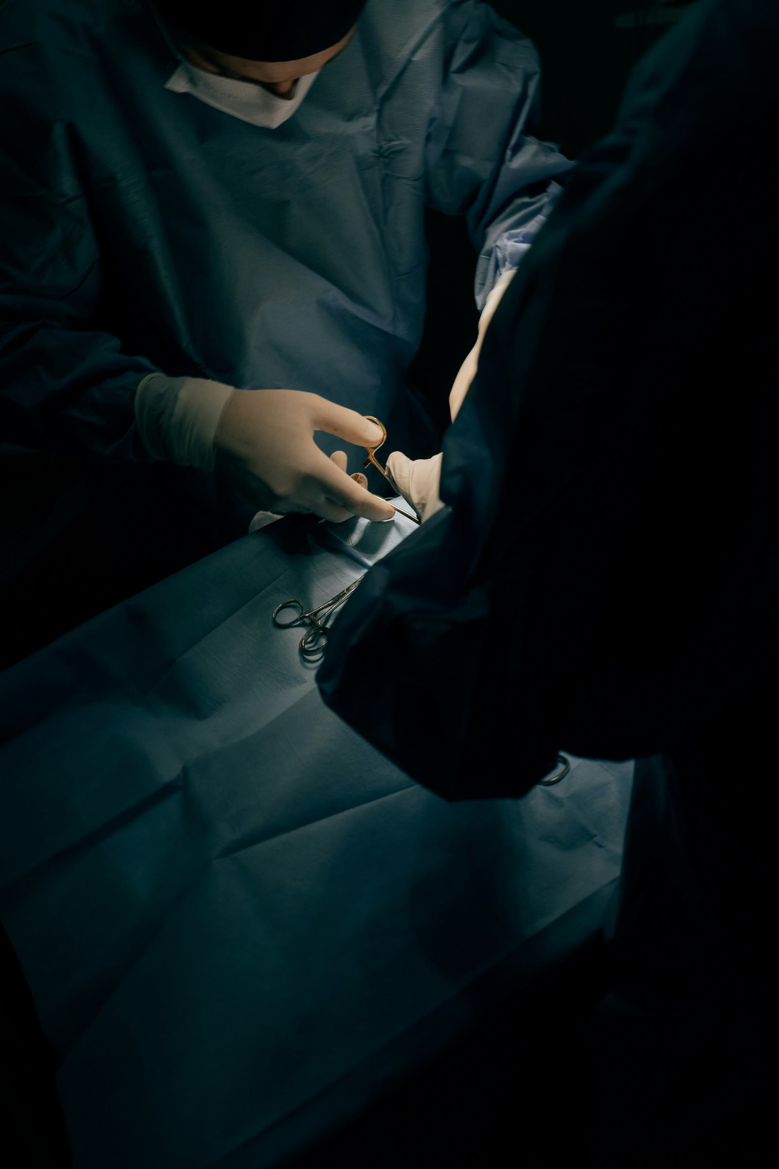Surgical team working under theatre lights with sterile instruments